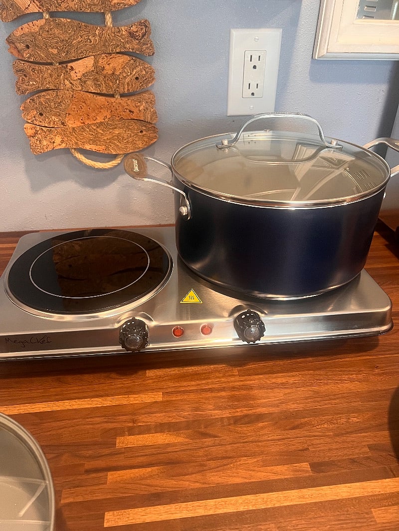 plug in stove top with pots and pans.