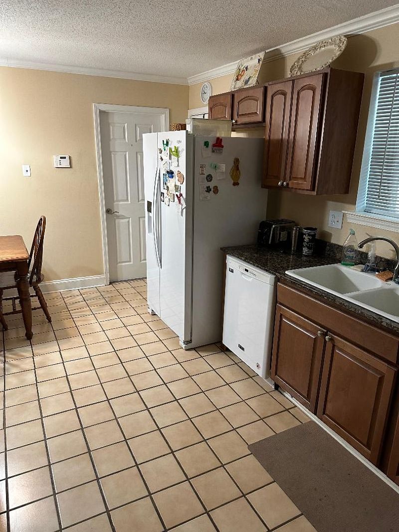full kitchen with fridge, dishwater, stove, oven, microwave. plates and utensils provided. indoor laundry room behind white door.