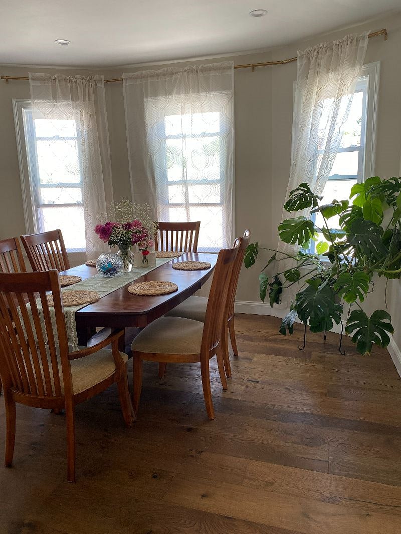 Warm and welcoming cherry wood dining table and the gorgeous Monstera plant.