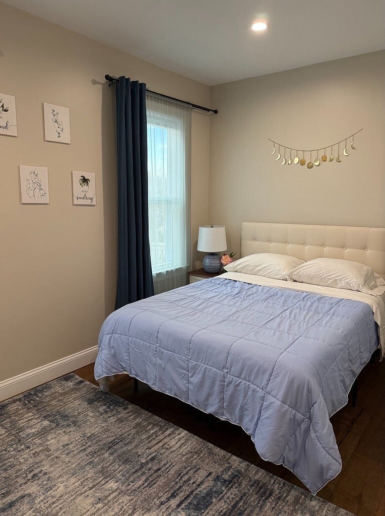 Room #1: The Moon Goddess. Large room with lots of natural light streaming from two windows. Full size bed, smart TV, nightstand, lamp, dresser, closet, and blackout curtains to reduce light and noise and to create a quiet and peaceful environment.