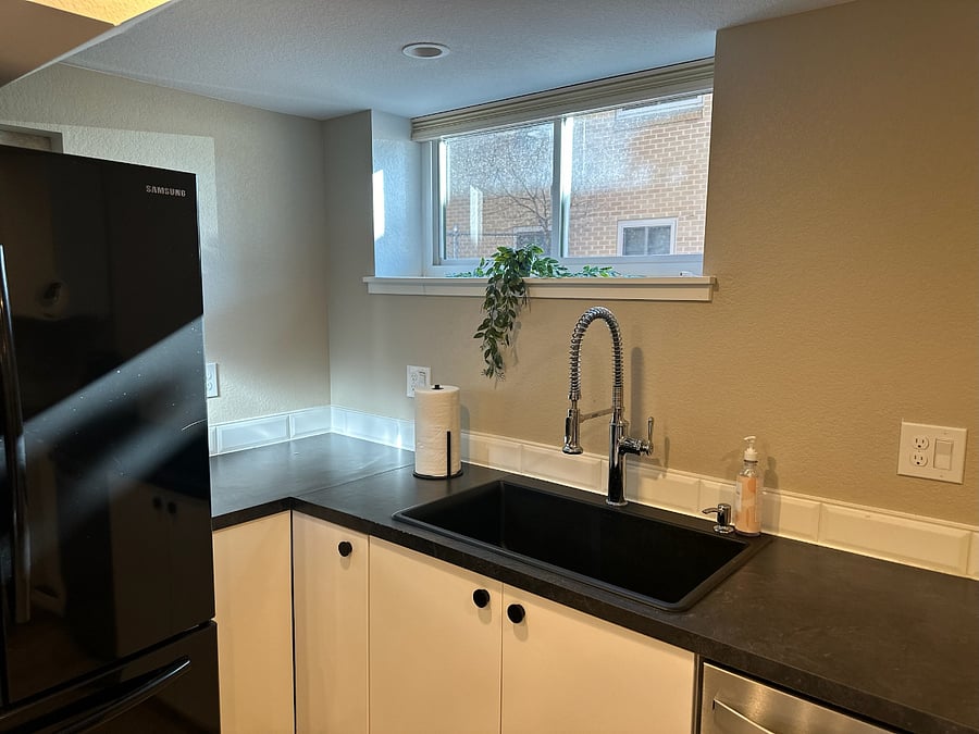 Kitchen sink area with nice natural lighting and functional pull-down faucet with spray features.