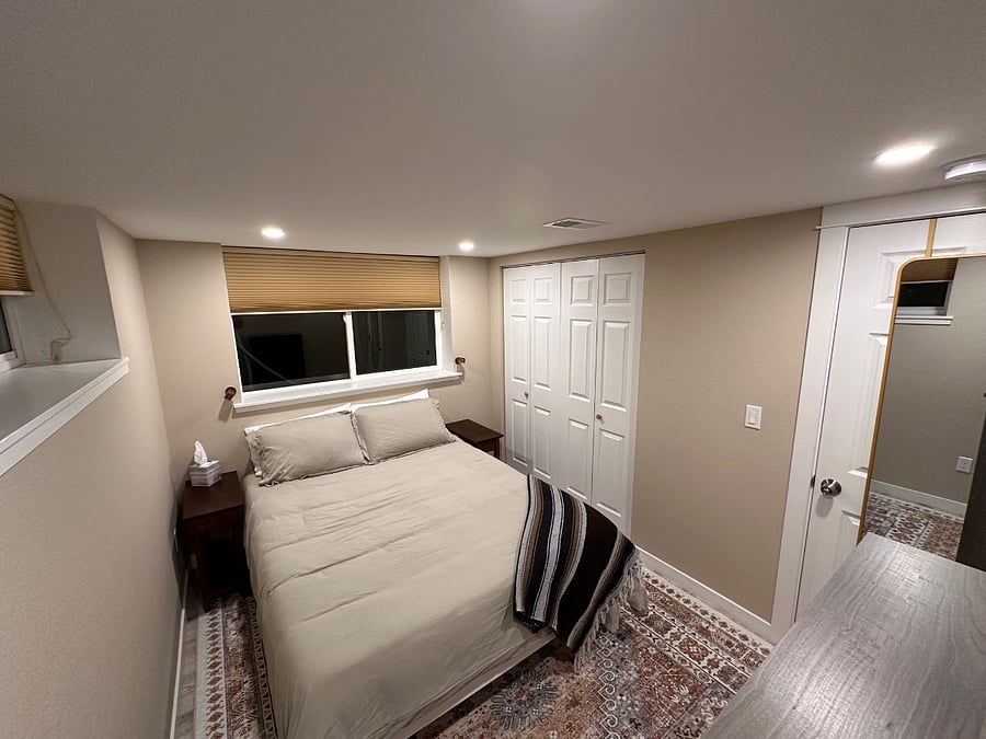 Main bedroom with plush memory foam mattress, bamboo sheeting, microfiber duvet cover, and cool wall-mounted dimmable LED lights for evening reading - the closet is through the doors on the right.