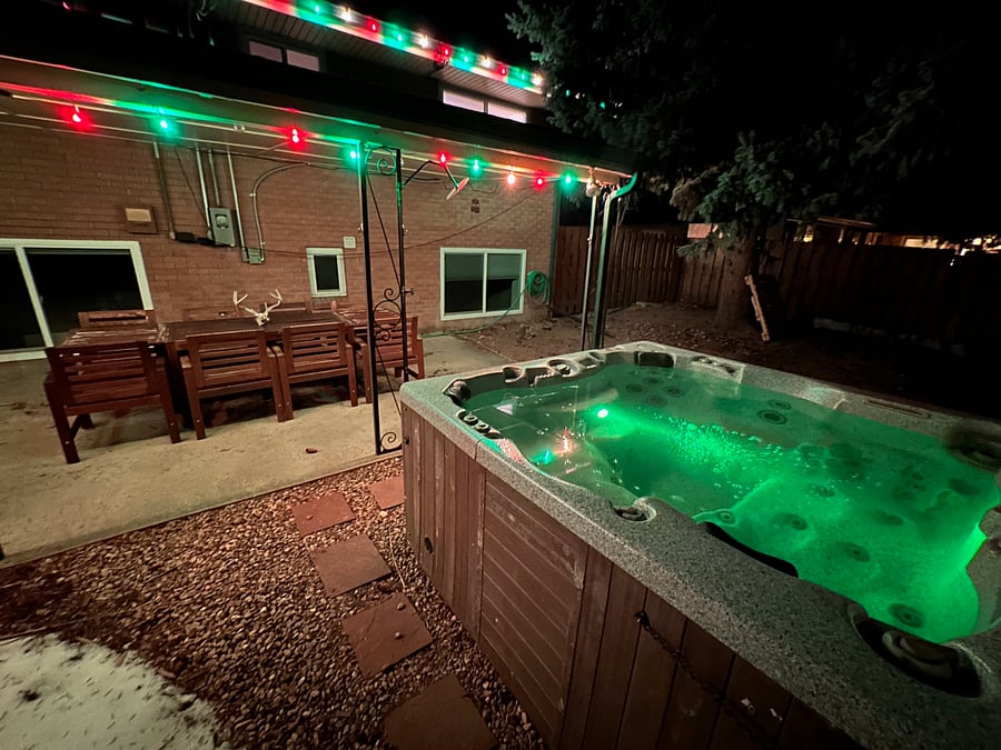Hot tub and patio at night (Picture was taken while we still had bulbs in for Christmas! We usually rotate colors for holidays but keep the regular soft yellow installed in between).