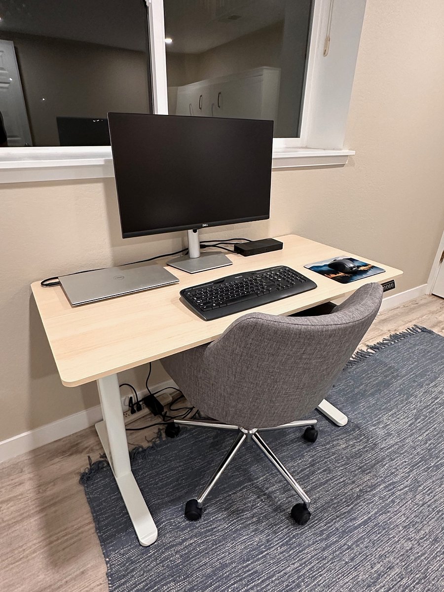 Up close view of workstation with sit-stand desk, wireless keyboard/mouse, Dell docking station, and beautiful 27" Dell 4K monitor.