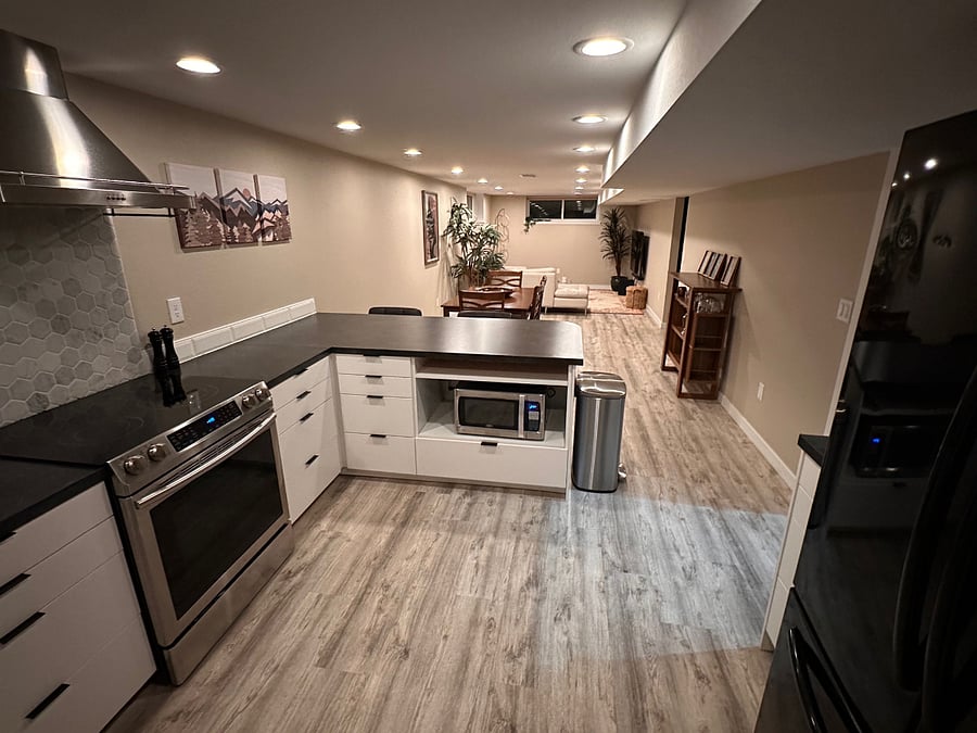 View from kitchen towards main living space with microwave tucked below the countertop to free up more space.