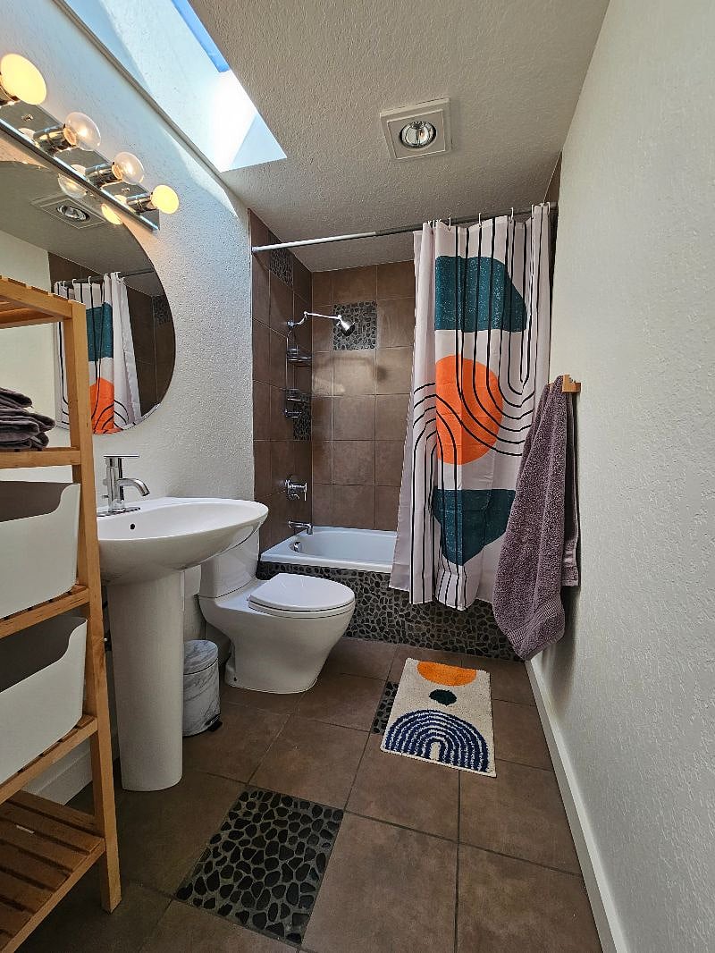 River rock bath with dual-flush toilet.