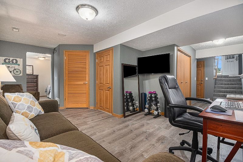 Basement with small workout area and dedicated working area with laser printer, keyboard and monitor to stay