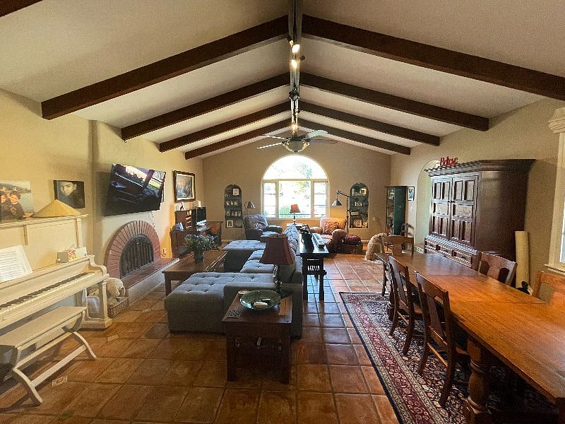 Living room with cozy reclining couch, leather chairs, piano, and lovely mountain views.Co