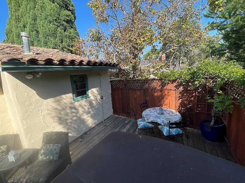 Back deck with jacuzzi, dining and seating areas.