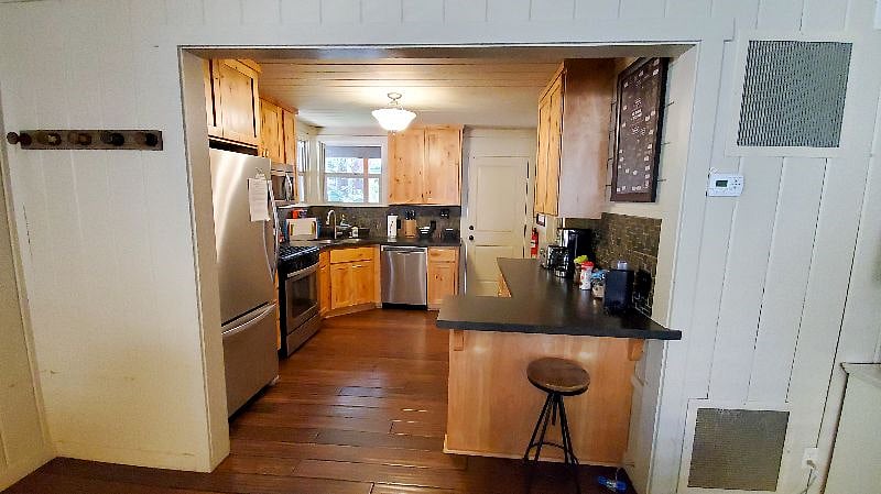 The kitchen has a gas stove, dishwasher, drip coffee maker, refrigerator, toaster, pots, pans, dishes, and more. The laundry is connected to the kitchen.