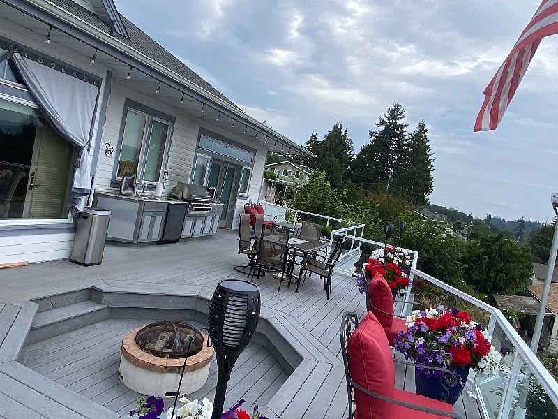 The deck has a fire pit, mini fridge, sink, and barbecue with access to a fenced backyard for dogs