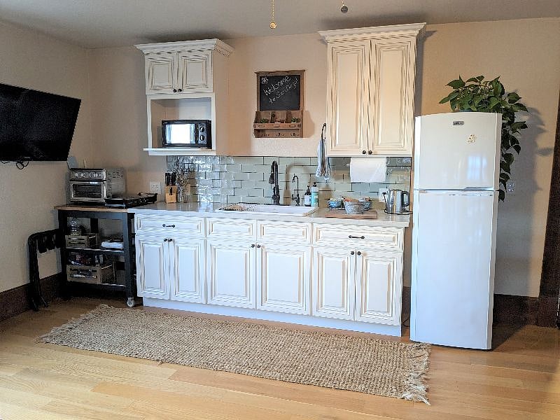Your kitchenette: including a full-size refrigerator, sink, oven and 2 double, electric hotplates. The TV folds forward to face the couch when in use.
