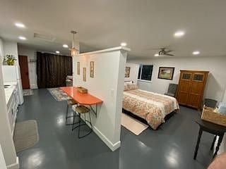 Kitchen, retro bar counter with stools, bedroom, workspace enclosed in cabinet and chair.