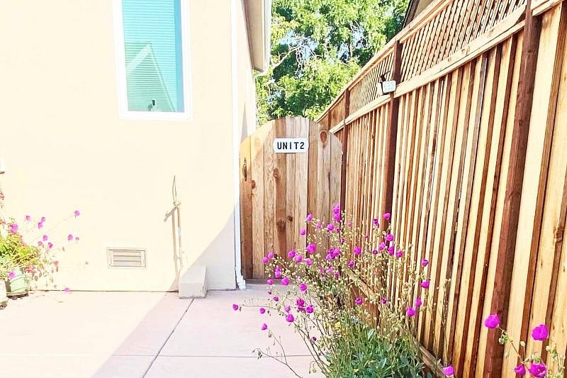 Second fence door entrance (marked 'Unit 2') which is your private entrance to the Guesthouse. Looking inside after the first fence entrance door. Summer blooms offering a bright welcome to the guests