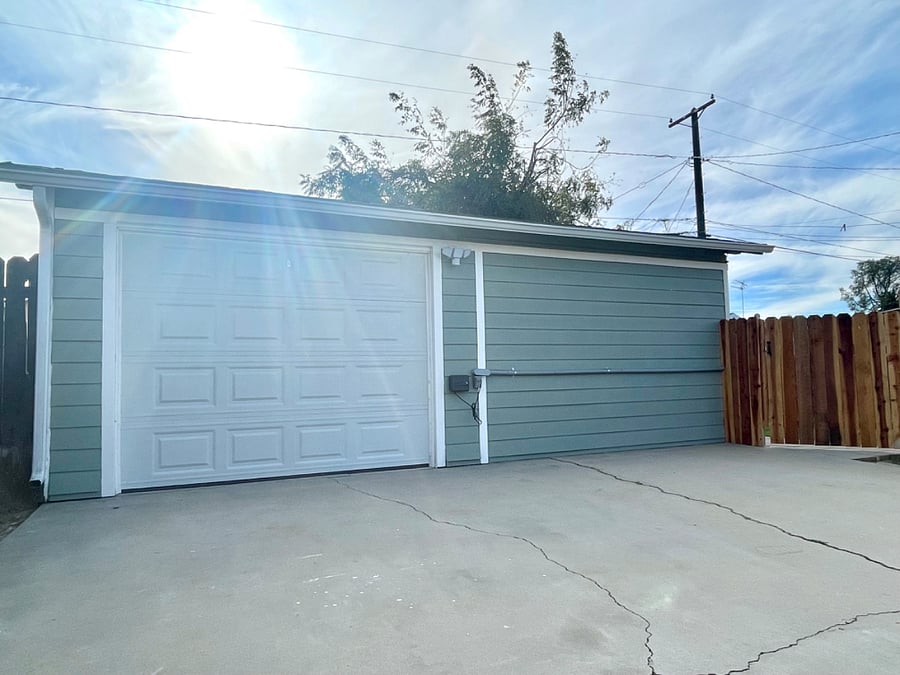Little Green Casita studio located separately from front house. Studio entrance located behind wooden fence. Washer and dryer located in garage area. Designated parking for studio guests is located on driveway, in front of garage door.