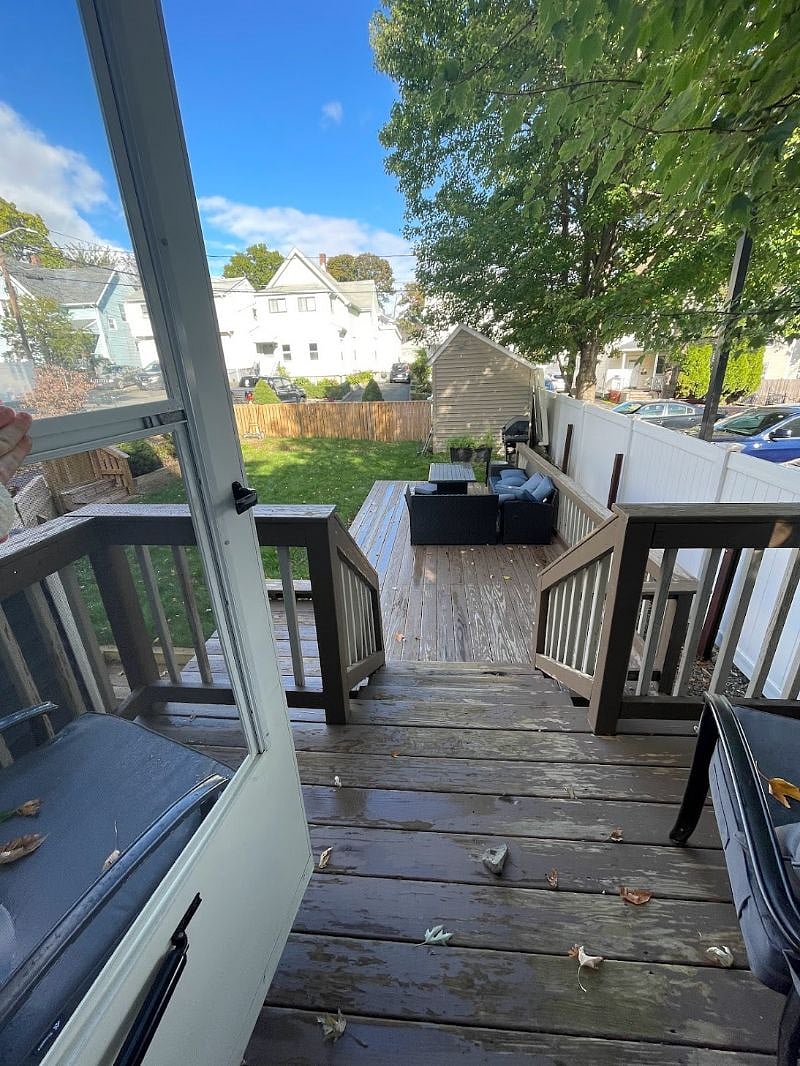Large porch with outdoor furniture for relaxing, small yard that is semi fenced in