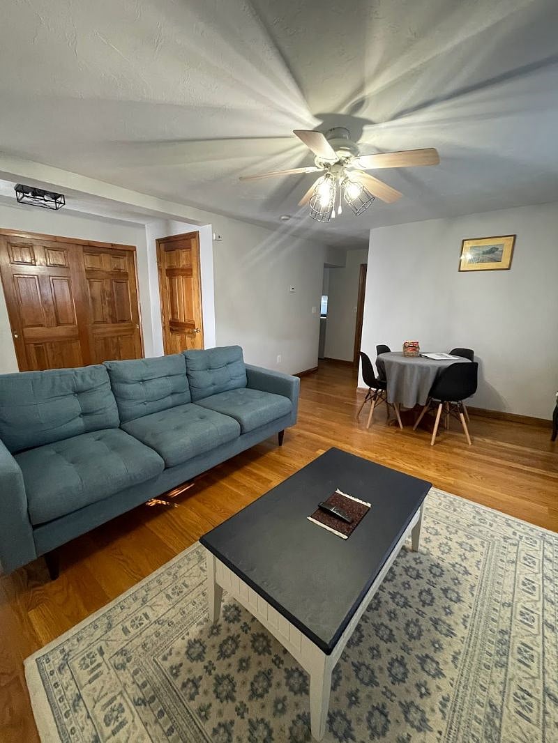 Living room with large Smart TV, dining area, and coffee bar