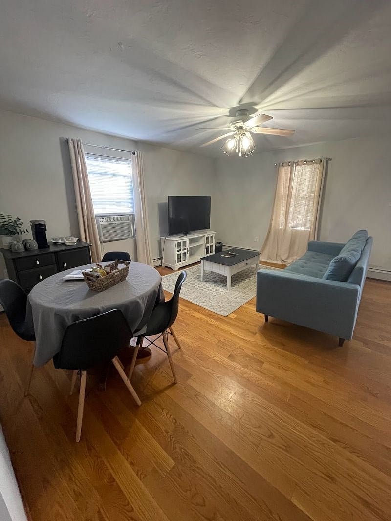 Living room with large Smart TV, dining area, and coffee bar