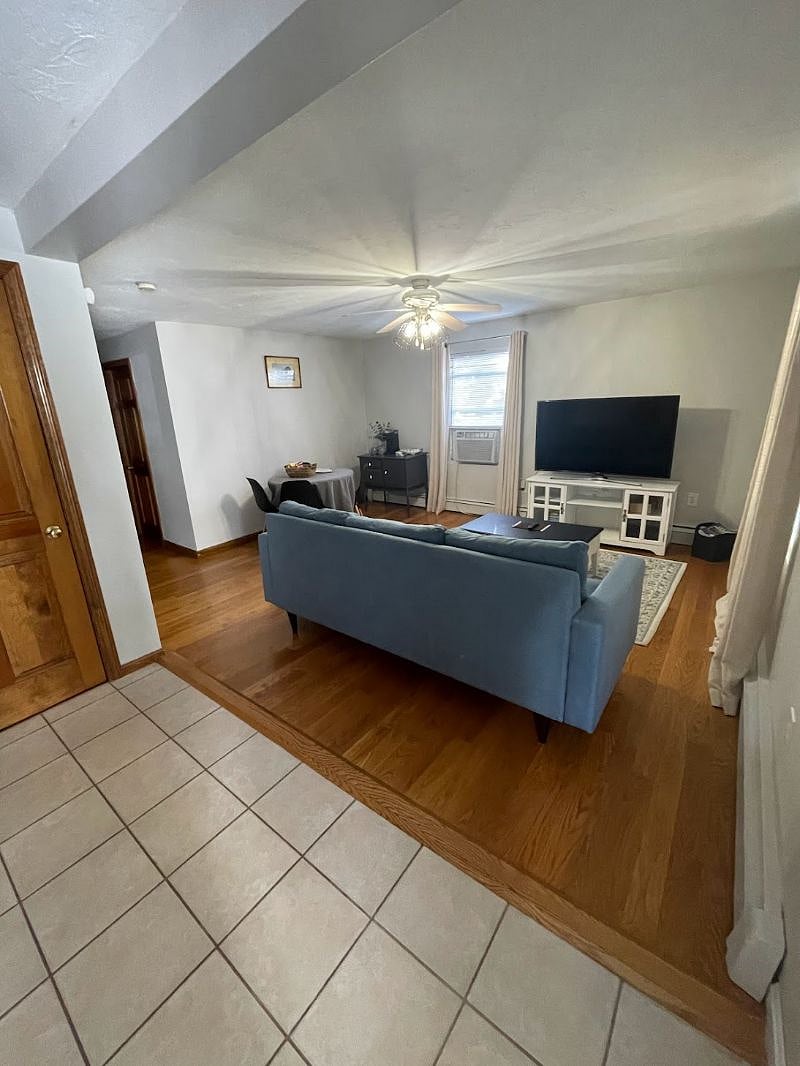 Living room with large Smart TV, dining area, and coffee bar
