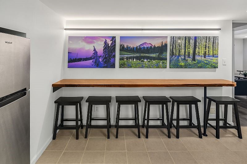 The kitchen features a one of a kind 10 foot walnut live-edge bar which seats 6 people.  The bar was handmade by a local craftsman and it provides striking three dimensional effects in the wood grain.