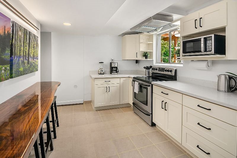The kitchen features a one of a kind 10 foot walnut live-edge bar which seats 6 people.  The bar was handmade by a local craftsman and it provides striking three dimensional effects when looking closely at the wood grain.