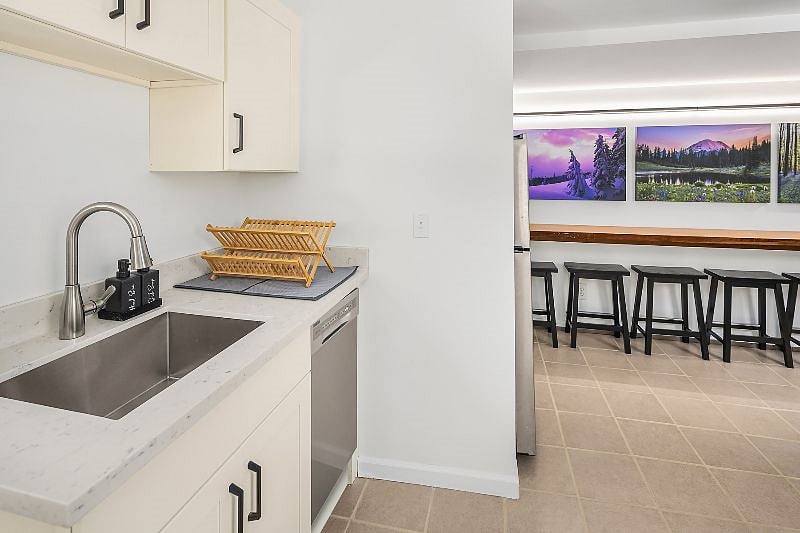 The kitchen includes a deep stainless steel sink, a drying rack, and a dishwasher which makes kitchen cleanup a breeze.