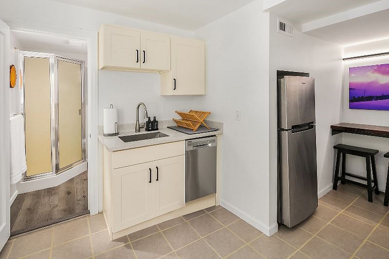 The kitchen includes a deep stainless steel sink, a drying rack, and a dishwasher which makes kitchen cleanup a breeze.