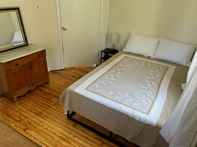 Bedroom 1, double bed, bedside table with lamp and charging station for phone, closet and desk