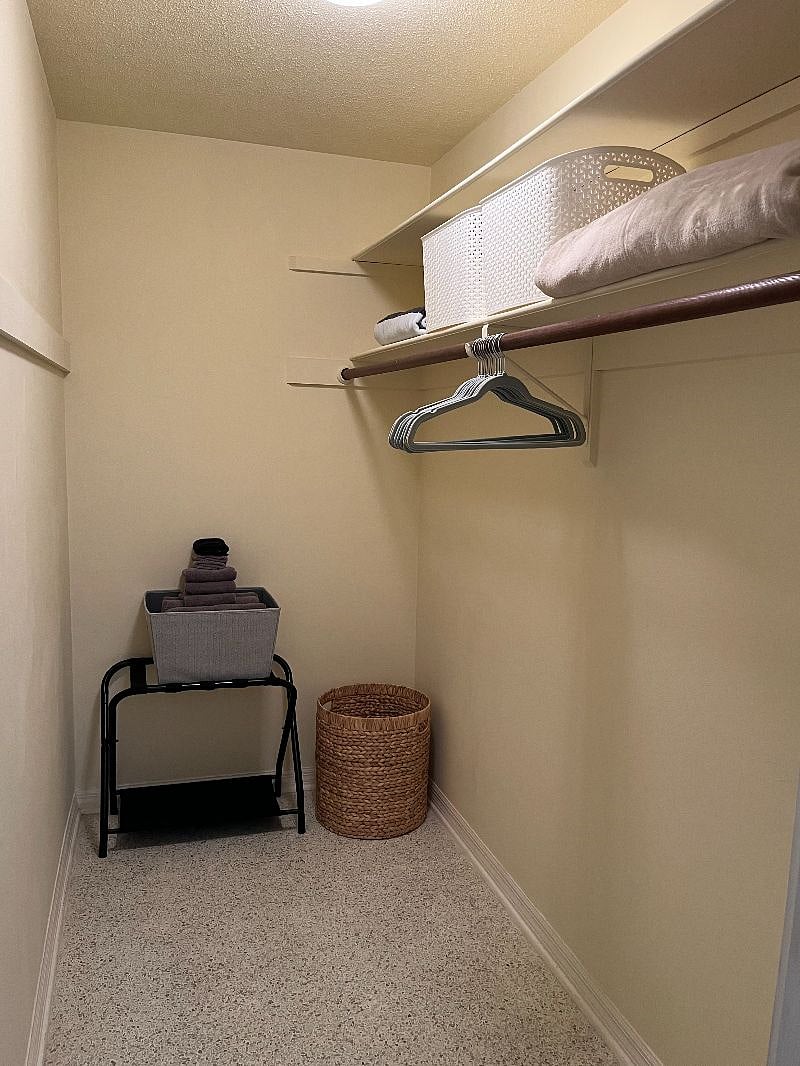 This walk-in closet has an enormous amount of room. Store your clothes and hide your luggage away.