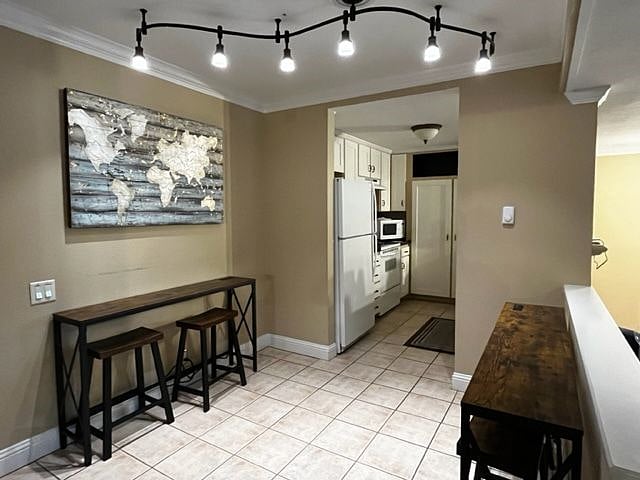 Dining area with smart table set up for ADA accessibility to kitchen. (Old kitchen appliances in view).