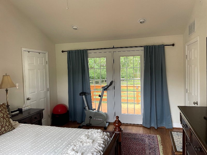 Master bedroom with French doors to deck and exercise bike