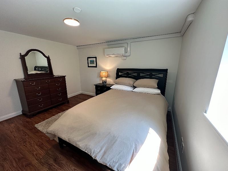 Comfortable queen bed with nightstand and dresser. Bedroom also has blackout curtains and a TV.