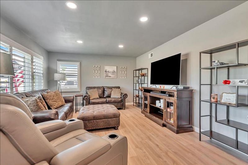 Cozy living room: love seat, queen sofa bed, 65 smart TV, board games.