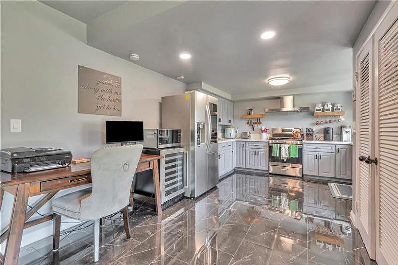 Our eat-in kitchen boasts a side-by-side fridge and freezer, a wine fridge, a gas oven/stove setup, a charming farmhouse sink and convenient microwave.