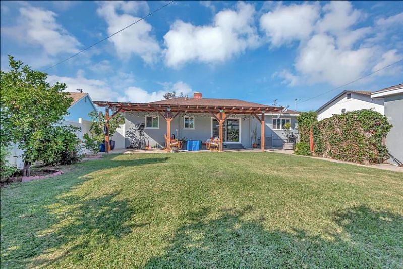 Backyard with garage and patio access, lemon, grapefruit, orange trees, and beautiful rose bushes a serene outdoor haven.