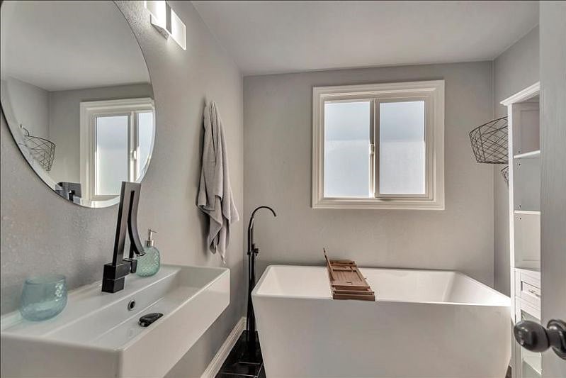 Elegant guest bathroom: Soaking tub, sleek storage.