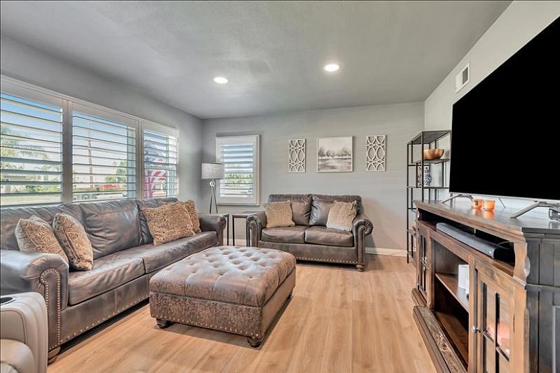 Cozy living room: love seat, queen sofa bed, 65 smart TV, board games.