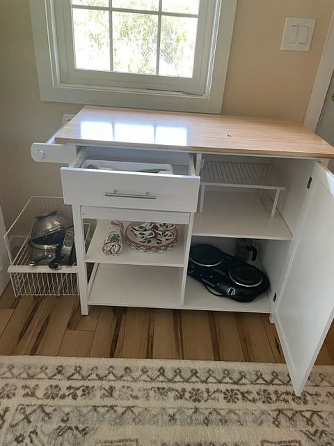 Kitchen cart with hot plate, utensils, plates, cups, a few pots and pans for light cooking and space for small amount of food.