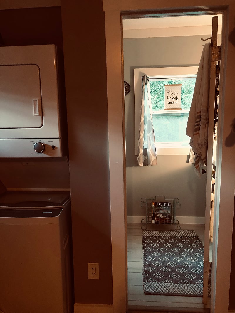 washer and dryer on the left with shelving storage before going into bathroom