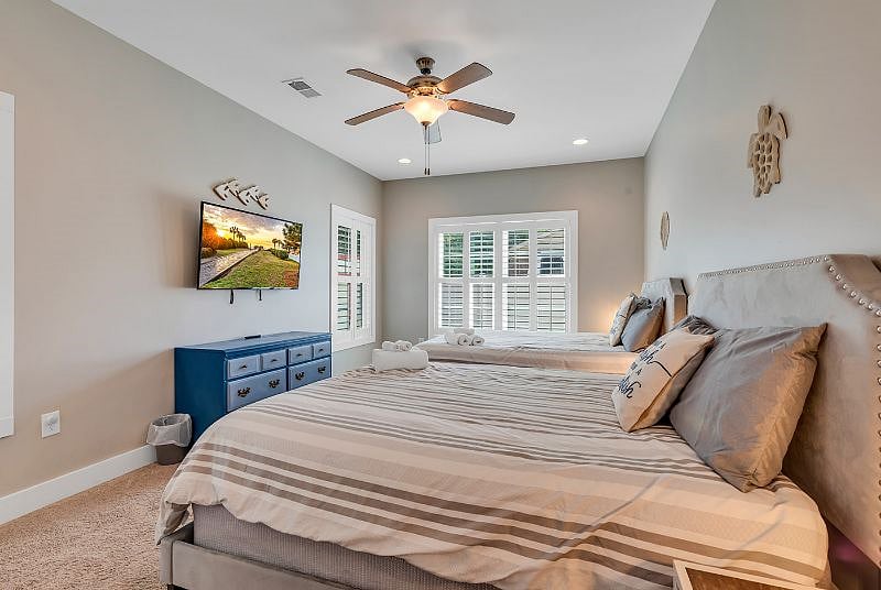 Large bedroom on lower level with lots of windows covered with plantation shutters. Smart TV and 2 Queen beds! Perfect for roommates or guests!
