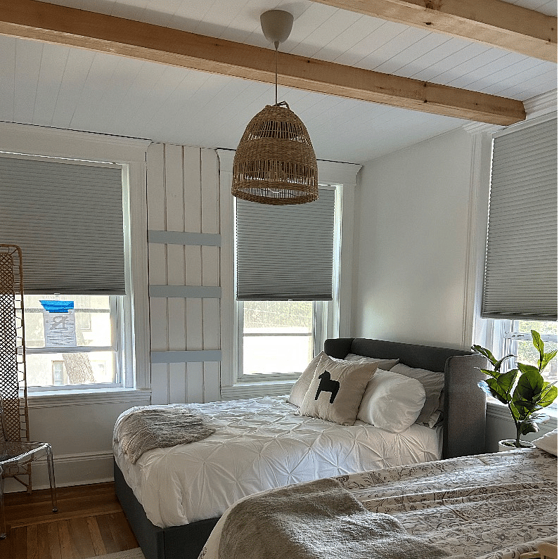 Full size extra linens in basket under mirror in bedroom.