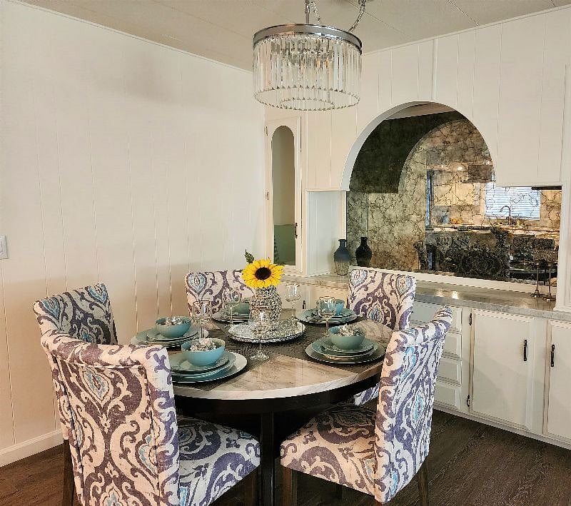 Formal dining area with crystal chandelier and mirrored elegance