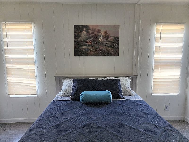 Spacious bedroom with queen-sized bed, 55" TV, and private bath access