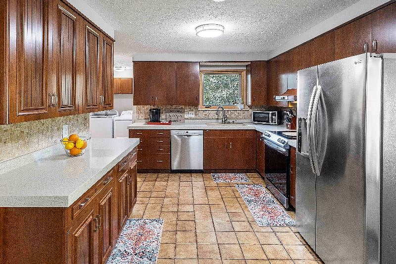 Large kitchen with dishwasher, oven/stove, microwave/air fryer, and full size refrigerator with ice maker/water in door