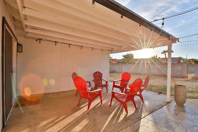 Covered backyard patio with Adirondack chairs