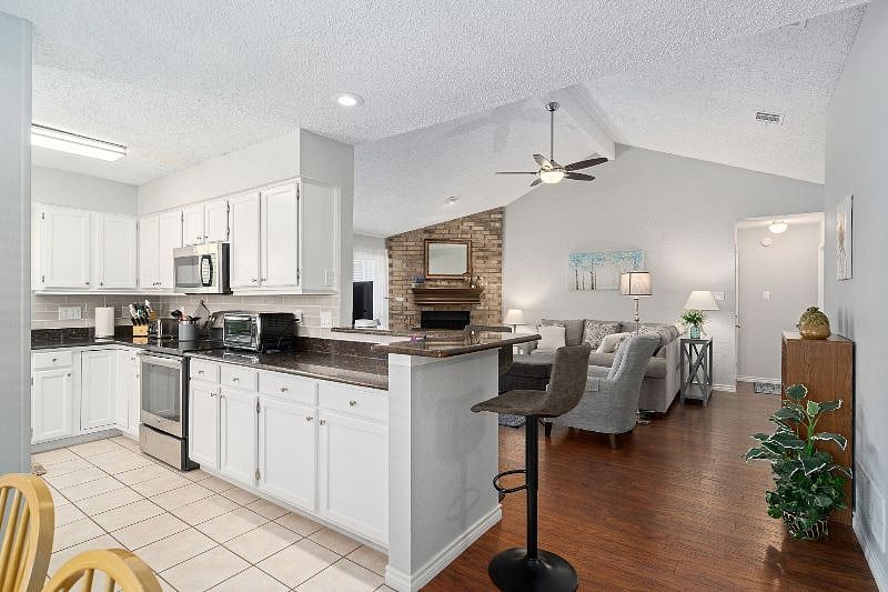 Kitchen view into living room with high bar stools for working or eating on the raised countertop