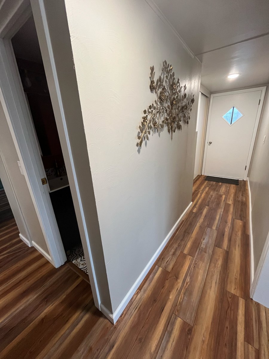 The door on the left is the bathroom and the hallway leads to the exterior deck