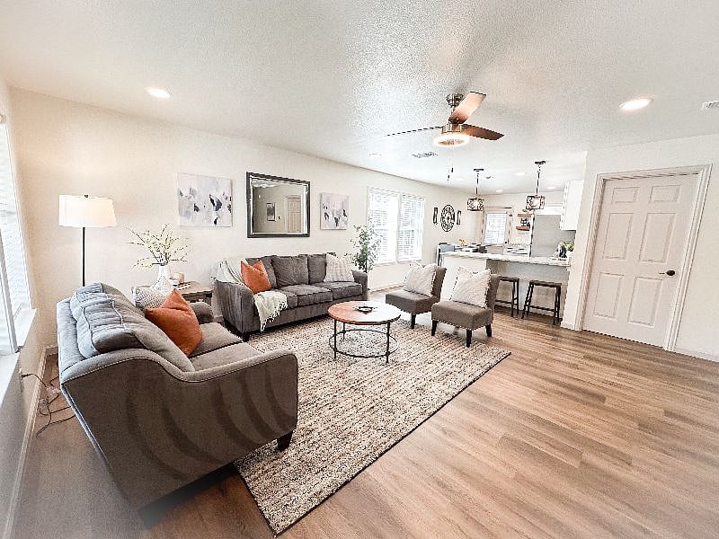 Open concept living room with beautiful stylish decor. Large windows with ample natural light