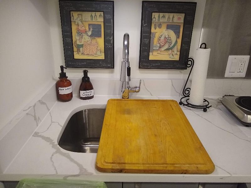 The board provides extra space for preparing meals. It is stored at the bottom of the under-counter cabinet.
Please do not use it as cutting board.