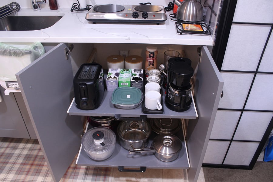Two sliding shelves:
Top shelf is for making coffee, tea, and toasts.
Lower shelf is for pots, pans, salad spinner, mixing bowls, wash bowl, colander, and measuring cup.
When not in use, the shelves can be pushed back into the cabinet and the cabinet doors can be closed.